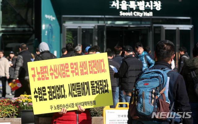 【서울=뉴시스】추상철 기자 = 옛 노량진수산시장 상인이 13일 오전 서울 중구 서울시청 앞에서 연좌농성을 하고 있다. 2018.11.13. scchoo@newsis.com