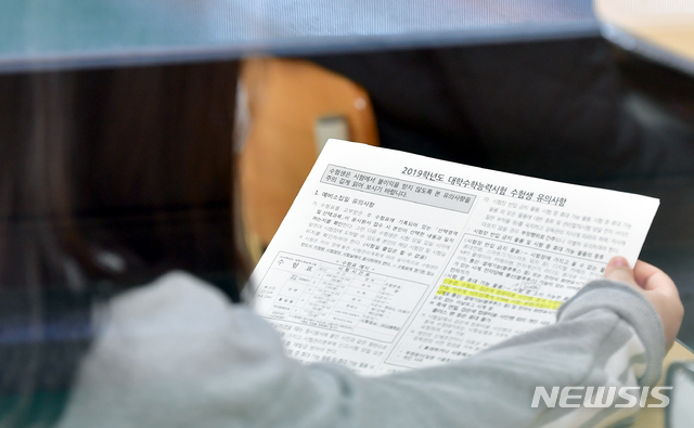 【광주=뉴시스】류형근 기자 = 2019학년도 대입 수학능력시험을 하루 앞둔 14일 오전 광주 동구 설월여고에서 수험생이 수능 예비소집에 앞서 유의사항을 살펴보고 있다. 2018.11.14.  hgryu77@newsis.com