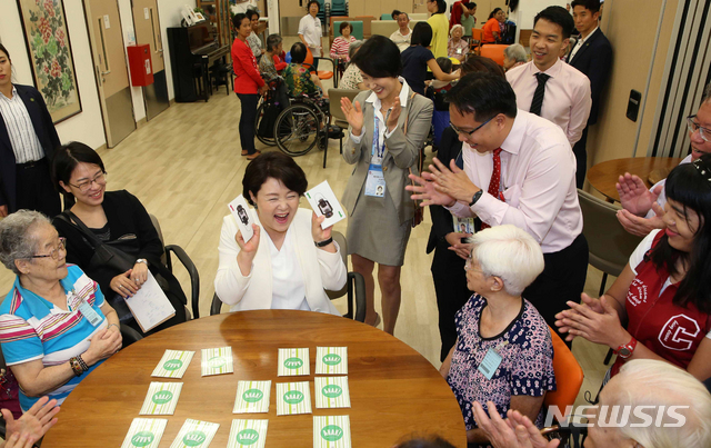 【싱가포르=뉴시스】박진희 기자 = 문재인 대통령 부인 김정숙 여사가 14일(현지시간) 싱가포르 꽝와이시우 요양병원을 방문해 입원중인 노인들과 함께 그림 맞추기 게임을 하고 있다. 2018.11.14. pak7130@newsis.com