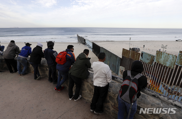 【티후아나(멕시코) = AP/뉴시스】14일 멕시코국경의 티후아나에 도착해서 미국 샌디에이고쪽의 국경장벽을 바라보고 있는 중미 이민들. 이들은 수백명씩 버스와 트럭을 얻어 타고 빠른 속도로 국경으로 도착하고 있다.&nbsp;&nbsp; 