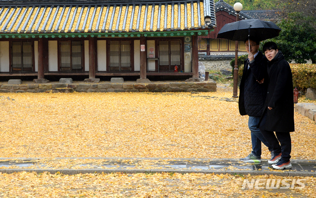 【전주=뉴시스】김얼 기자= 서늘한 바람과 함께 비가 내린 16일 전북 전주시 완산구 교동 전주향교 명륜당 앞에서 관광객들이 떨어져 내린 낙엽을 밟으며 늦가을의 정취를 느끼고 있다. 2018.11.16 pmkeul@newsis.com