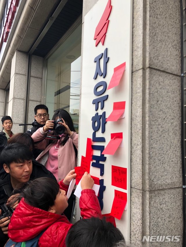 【서울=뉴시스】박미소 수습기자 = 정치하는엄마들, 동탄유치원사태비상대책위원회, 참여연대 등이 17일 오전 서울 영등포구 자유한국당 당사 앞에서 '비리유치원 비호세력 자유한국당 규탄 긴급 기자회견'을 열고 당사에 퇴장을 의미하는 '레드카드'를 붙이는 퍼포먼스를 하고 있다. 2018.11.17. 