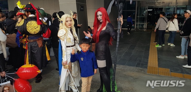 【부산=뉴시스】오동현 기자 = 17일 부산 벡스코(BEXCO)에서 열린 국제게임전시회 '지스타2018'에서 코스프레 모델과 사진을 찍고 있는 관람객 김성혁(6)군. 2018.11.17 odong85@newsis.com