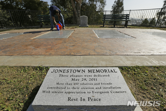 【오클랜드 = AP/뉴시스】 지난 10월 25일 오클랜드의 에버그린 묘지에서 인민사원 집단 자살사건의 희생자 900여명을 추모하는 기념판을 존스 목사의 양자였던 짐 존스 2세가 설치하고 있다. 11월 18일 집단 자살 40주기를 맞아 이 묘지에서는 가이아나의 밀림지대 '인민사원'에서 죽음을 맞은 뒤 이 곳에 묻힌 주민 400여명을 위한 추모행사가 열렸다.&nbsp; 