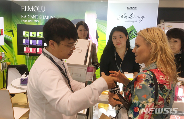 【대구=뉴시스】김덕용 기자 = '2018년 홍콩 코스모프로프 아시아'에 참가한 에스엘씨 관계자가 자사 부스를 방문한 해외 바이어에게 제품 설명을 하고 있다. 2018. 11. 20.(사진=대구테크노파크 제공)&nbsp; photo@newsis.com