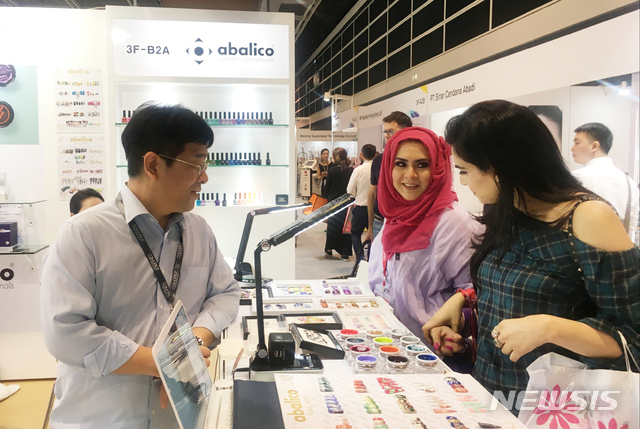 【대구=뉴시스】김덕용 기자 = '2018년 홍콩 코스모프로프 아시아'에 참가한 지역기업 아발리코코리아 관계자가 자사 부스를 방문한 참관객들에게 제품 설명을 하고 있다. 2018. 11. 20.(사진=대구테크노파크 제공) photo@newsis.com