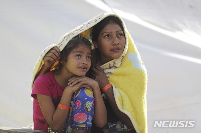 【티후아나=AP/뉴시스】 중남미 이민행렬 캐러밴에 참여하고 있는 한 모녀가 멕시코 북부 티후아나에서 19일 (현지시간) 휴식을 취하고 있다. 2018.11.20.