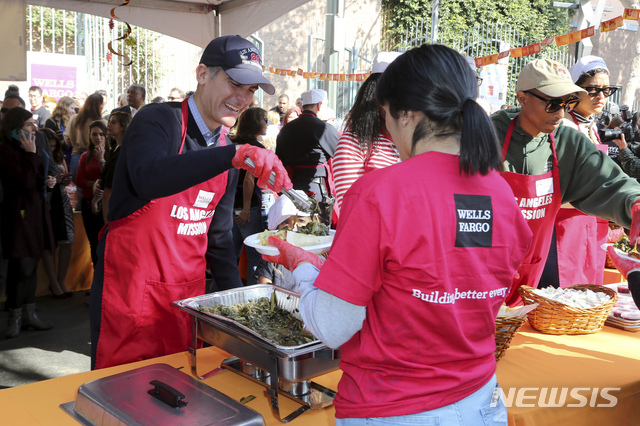 【로스앤젤레스=AP/뉴시스】 미국인들이 추수감사절용으로 구입해 먹는 칠면조는 4500만 마리에 이르며 전형적인 추수감사절 한끼 식사의 열량은 3150칼로리이다. 사진은 에릭 가세티 로스앤젤레스 시장(사진 왼쪽)이 21일 홈리스들에게 추수감사절 음식을 나눠주고 있는 모습. 2018.11.22