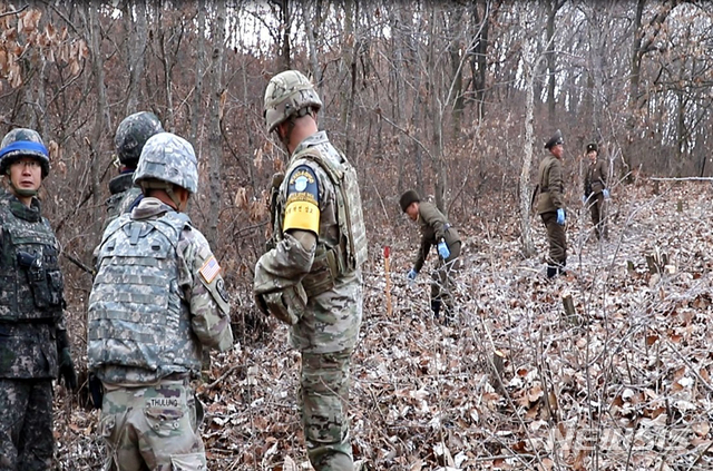 【서울=뉴시스】 국방부는 22일 남북군사당국이 '판문점선언 이행을 위한 군사분야 합의서'(9.19.)에 따라 공동유해발굴의 원활한 추진을 위해 강원도 철원 ‘화살머리고지’ 일대에서 남북 도로개설을 추진하고 있는 가운데, 도로연결 작업에 참여한 남북인원들이 MDL인근에서 상호 조우하는 모습의 사진을 공개했다. 2018.11.22. (사진=국방부 제공)&nbsp; photo@newsis.com