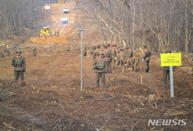 【서울=뉴시스】 국방부는 22일 남북군사당국이 '판문점선언 이행을 위한 군사분야 합의서'(9.19.)에 따라 공동유해발굴의 원활한 추진을 위해 강원도 철원 ‘화살머리고지’ 일대에서 남북 도로개설을 추진하고 있는 가운데, 도로연결 작업 모습의 사진을 공개했다. 사진은 북측 관계자들의 작업 모습. 2018.11.22. (사진=국방부 제공) photo@newsis.com