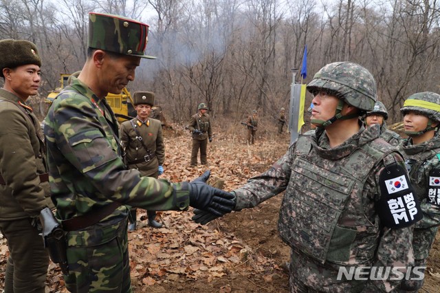 【서울=뉴시스】 국방부는 22일 남북군사당국이 '판문점선언 이행을 위한 군사분야 합의서'(9.19.)에 따라 공동유해발굴의 원활한 추진을 위해 강원도 철원 ‘화살머리고지’ 일대에서 남북 도로개설을 추진하고 있는 가운데, 도로연결 작업에 참여한 남북인원들이 MDL인근에서 상호 조우하는 모습의 사진을 공개했다. 2018.11.22. (사진=국방부 제공) photo@newsis.com