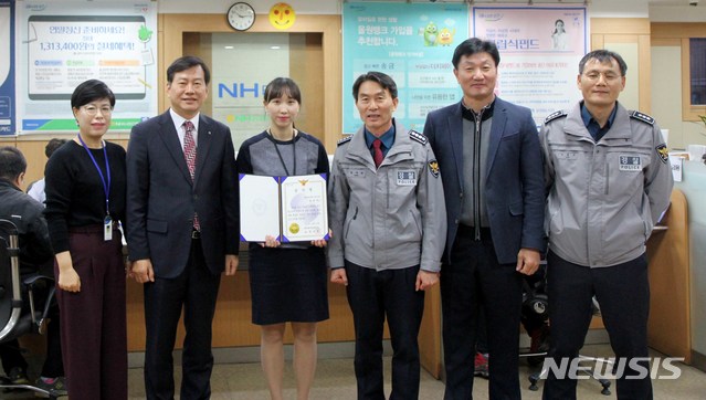 【광주=뉴시스】신대희 기자 = 22일 광주 북구 NH농협은행 운암동 지점에서 북부경찰서 경찰관들이 일명 '로맨스 스캠(romance scam·인터넷으로 거래 대금 등을 가로채는 신용 사기)'에 속아 수천만 원을 송금하려던 50대 여성의 피해를 예방한 손은지(30·여·왼쪽에서 세번째) 계장에게 감사장을 전달하고 있다. 2018.11.22. (사진 = 광주 북부경찰 제공) photo@newsis.com