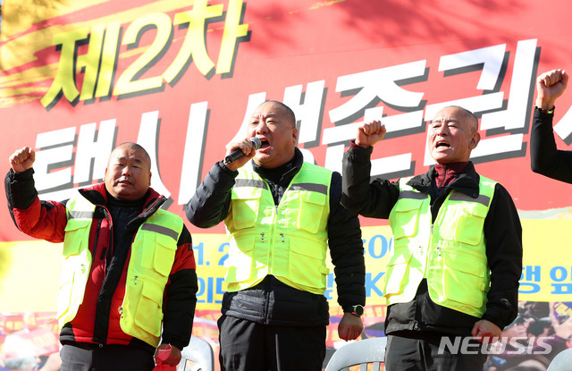 【서울=뉴시스】홍효식 기자 = 지난달 22일 오후 서울 여의도 국회 앞에서 열린 불법 카풀 앱 근절 제2차 택시 생존권 사수 결의대회에서 삭발식을 마친 참가자들이 구호를 외치고 있다. 2018.11.22. yesphoto@newsis.com