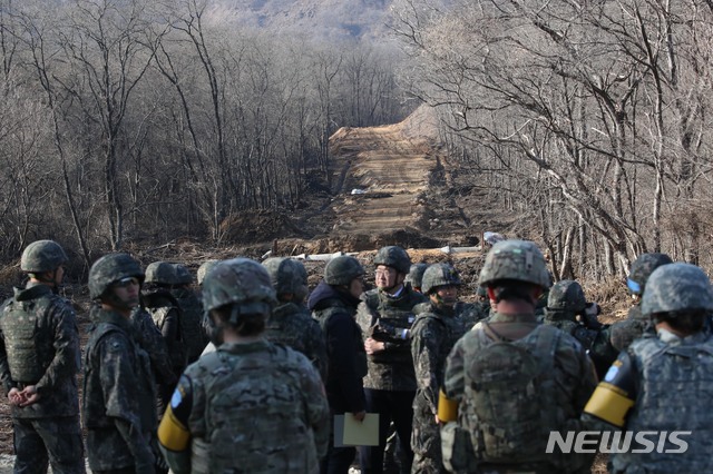 【철원=뉴시스】사진공동취재단 = 지난해 11월22일 오후  6ㆍ25 전쟁 당시 최대 격전지였던 강원도 철원 화살머리고지에서 남북이 비무장지대(DMZ) 안에서 아직까지 수습하지 못한 6ㆍ25 전쟁 전사자 유해를 공동으로 발굴하는 사업을 위한 남북공동 도로개설 작업 가운데 우리측 지역의 도로공사 현장을 국방부가 공개 했다. 남측 취재단이  군사분계선(MDL 사진속 건너편은 북한 지역이다) 바로 앞에서 취재하고 있다. 남북은 지난 9월19일 체결한 군사합의서에서 원활하게 유해를 발굴하기 위해 12ｍ 폭의 도로를 개설하고 군사분계선에서 연결한다고 합의 했다. 2019. 01.17 photo@newsis.com