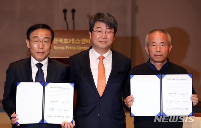 【서울=뉴시스】조성봉 기자 = 23일 오전 서울 중구 프레스센터 국제회의장에서 열린 삼성전자-반올림 중재 판정 이행 협의 협약식에서 김기남(왼쪽부터) 삼성전자 대표이사, 김지형 조정위원장, 반올림 황상기 대표가 협약서를 들고 기념촬영을 하고 있다. 2018.11.23. suncho21@newsis.com