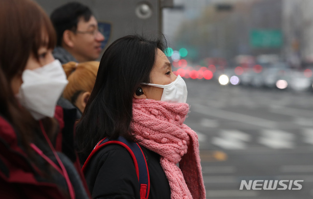 【서울=뉴시스】김진아 기자 = 전국 대부분 지역에 미세먼지 농도가 '나쁨' 수준을 보이고 있는 27일 오전 서울 종로구 광화문네거리에서 마스크를 착용한 시민이 발걸음을 재촉하고 있다. 2018.11.27.  bluesoda@newsis.com