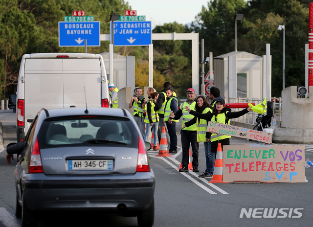 【비아리츠=AP/뉴시스】 27일(현지시간) 프랑스 남서부 비아리츠에서 정부의 유류세 인상에 반대하는 '노란 조끼' 시위대가 점령했던 도로를 열고 있다. 이날 에마뉘엘 마크롱 프랑스 대통령은 탈원전 목표 시기를 10년 미루겠다고 밝히며 유류세 인상에 항의하는 시위대를 달랬다. 2018.11.28.