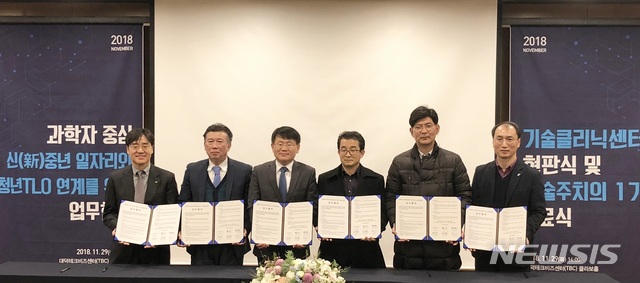 【대전=뉴시스】김양수 기자 = 연구개발특구진흥재단은 신중년 일자리사업과 청년TLO육성사업을 연계키로 하고 29일 TBC에서 대전대학교 산학협력단, 배재대학교 산학협력단, 충남대학교 산학협력단, 한남대학교 산학협력단, 한밭대학교기술지주㈜ 등 5개 기관과 업무협약을 체결했다. 양성광(왼쪽서 세번째) 특구재단 이사장이 5개기관 관계자들과 협약을 체결한 뒤 기념사진을 찍고 있다.2018.11.29(사진=연구개발특구진흥재단 제공) photo@newsis.com