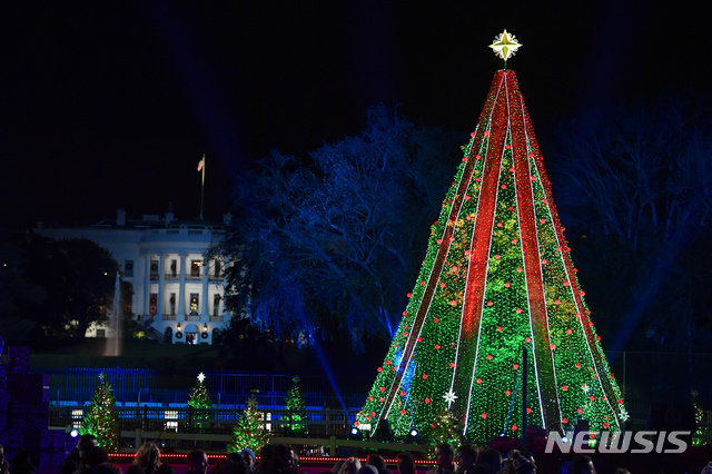 【워싱턴DC=AP/뉴시스】28일(현지시간) 백악관 근처 일립스(프레지던트파크 사우스)에서 제96회 내셔널 크리스마스트리 점등식이 열려 화려한 트리가 백악관을 배경으로 불을 밝히고 있다. 이 점등식은 제30대 대통령인 캘빈 쿨리지가 1923년 크리스마스이브에 처음으로 '내셔널 크리스마스트리'를 세우면서 시작돼 워싱턴 최고의 크리스마스 전통으로 이어지고 있다.2018.11.29.