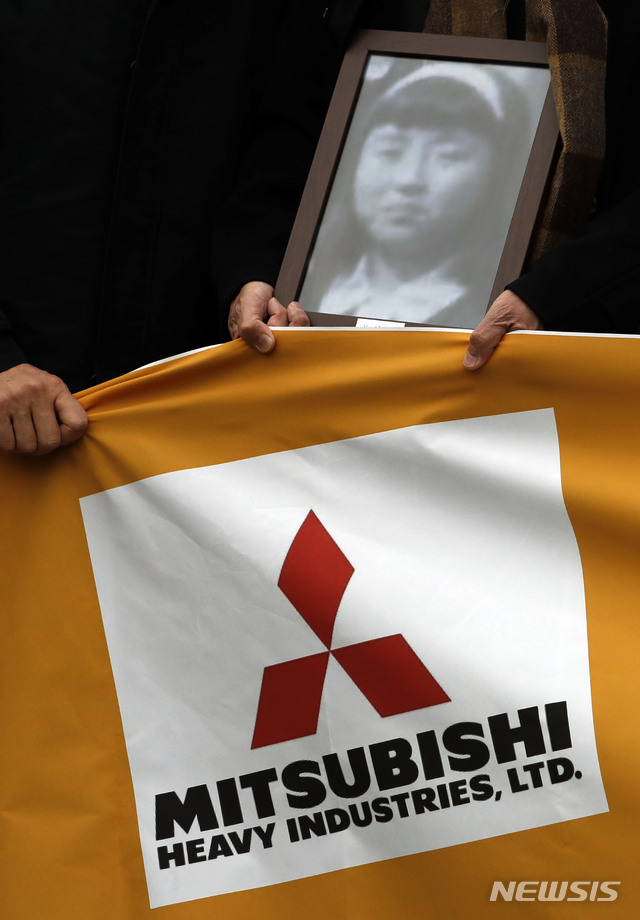 【서울=뉴시스】최동준 기자 = 미쓰비시중공업 강제동원 피해자 손배소 대법원 판결을 앞둔 29일 오전 서울 서초구 대법원 앞에서 한 시민단체 회원이 강제동원 피해자 고 김순례 씨의 영정사진을 들고 있다. 2018.11.29.&nbsp; photocdj@newsis.com