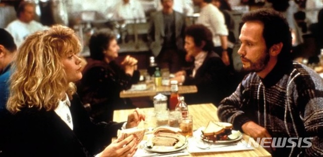 【로스앤젤레스=뉴시스】 영화 '해리가 샐리를 만났을 때'의 주인공 빌리 크리스털과 멕 라이언. 영화 속에서 샐리 올브라이트 역을 맡은 멕 라이언이 가짜로 성적 성적 쾌감을 느끼는 연기를 하며 화제가 된 레스토랑 대화 장면. <사진=콜럼비아 픽처스 캡처> 2019.04.11
