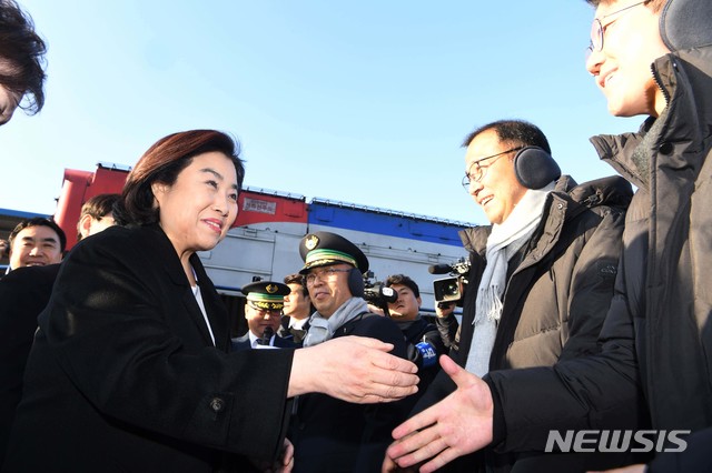 【파주=뉴시스】사진공동취재단 = 30일 경기도 파주 도라산역에서 북한 신의주로 가는 남북철도현지공동 조사단이 탄 열차가 북한으로 출발 하기전 박순자 국토위원장이 조사요원에게 방한귀마개를 전달한 뒤 악수하고 있다. 2018.11.30.&nbsp; photo@newsis.com