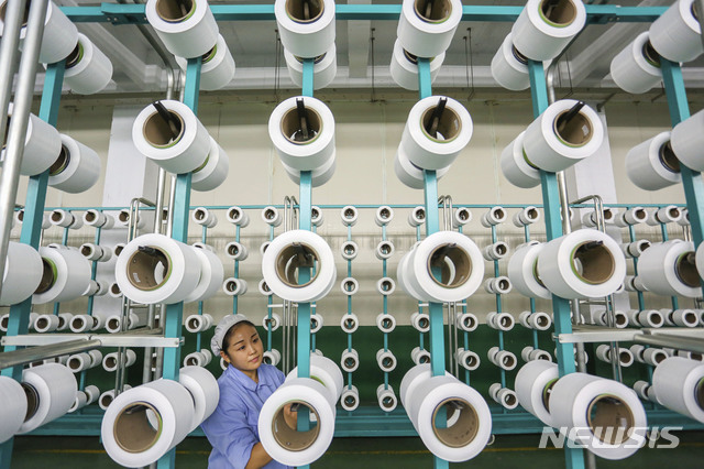 【진장=AP/뉴시스】30일 중국 국가통계국은 11월 제조업 PMI는 50.0을 기록했다고 발표했다. 이는 전월치인 50.2와 시장 예상치인 50.1에 모두 못 미치는 수치이자 지난 2016년 7월(49.9) 이후 최저다. 지난 11월 22일 푸젠성 진장시의 한 방직공장에서 한 노동자가 일하고 있다. 2018.11.30