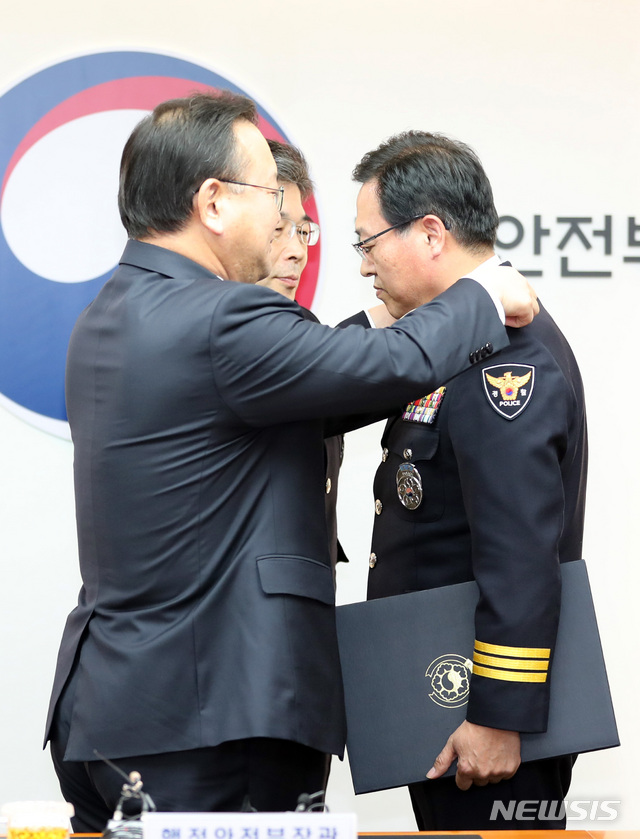 【서울=뉴시스】전진환 기자 = 신임 경찰지휘부 임명장 수여식이 열린 3일 오후 서울 종로구 행정안전부에서 김부겸 행안부 장관이 치정감으로 승진한 이용표 신임 부산경찰청장에게 계급장을 달아주고 있다. 2018.12.03.&nbsp; amin2@newsis.com