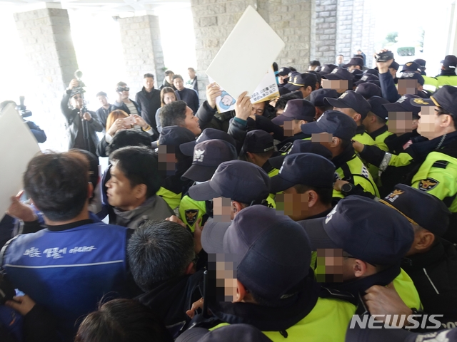 【제주=뉴시스】조수진 기자 = 5일 오후 녹지국제병원 조건부 개설 허가 발표를 규탄하는 의료민영화저지와 의료공공성강화를 위한 제주도민운동본부가 제주도청 안으로 들어가려 했으나 경찰에 제지당하고 있다. 2018.12.05. susie@newsis.com