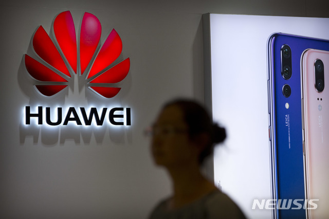 FILE - In this July 4, 2018, file photo, a shopper walks past a Huawei store at a shopping mall in Beijing. Canadian authorities said Wednesday, Dec. 5, 2018, that they have arrested the chief financial officer of China's Huawei Technologies for possible extradition to the United States. (AP Photo/Mark Schiefelbein, File)