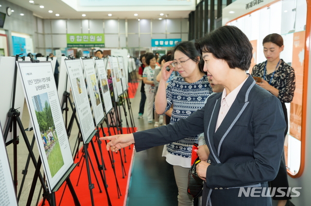 【서울=뉴시스】박대로 기자 = 작년 보도기획전에서 주민들과 기사보고 있는 김수영 양천구청장. 2018.12.07. (사진=양천구 제공)