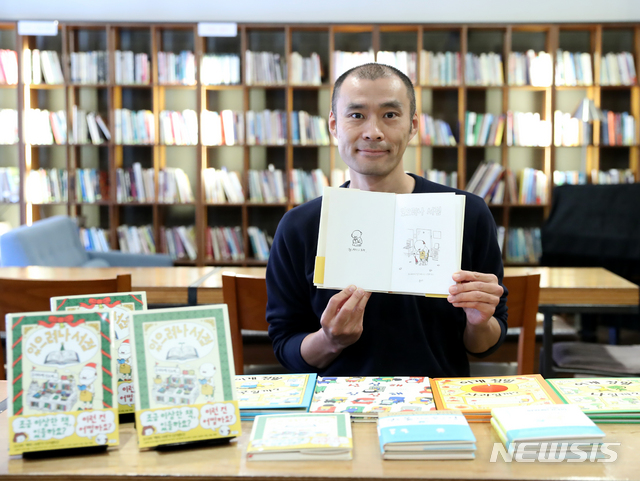 【서울=뉴시스】조수정 기자 = 일본 그림책 작가 요시타케 신스케(ヨシタケシンスケ)가 7일 오전 서울 중구 정동 프란치스코교육회관 내 산다미아노 카페에서 열린 '있으려나 서점' 출간 간담회에서 자신의 책에 그림을 그린 뒤 포즈를 취하고 있다. 앞에는 그동안 그가 출간한 책이 놓여있다. 요시타케 신스케는 2017년 이탈리아 볼로냐 국제아동도서전 라가치상(Bologna Rgazzi Awards) 특별상 수상 작가다. 2018.12.07. chocrystal@newsis.com