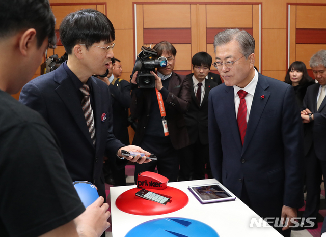 【서울=뉴시스】전신 기자 = 문재인 대통령이 7일 서울 삼성동 코엑스에서 열린 제55회 무역의 날 기념식에서 스타트업 기업의 피부프린팅이 가능한 문신형 프린터에 대한 설명을 듣고 있다. 2018.12.07. photo1006@newsis.com