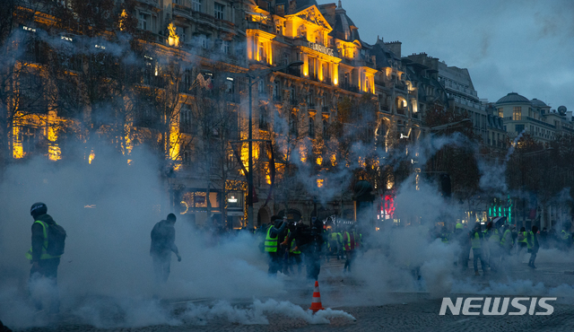 【파리(프랑스)=뉴시스】 이준성 프리랜서 기자 = 유류세 인상 발표로 시작된 노란조끼 시위가 한 달째(4회차) 이어지고 있다. 8일(현지시간) 프랑스 파리 샹제리제 거리가 최루가스로 뒤덮이고 있다. 정부는 기물파손, 인명피해 등 시위대의 과격한 행동을 우려해 이날 에펠탑과 루브르 박물관, 오르세 미술관 등 파리 및 전국 주요 관광 명소와 공공시설을 임시로 폐쇄했으며, 샹젤리제거리 일대의 거의 모든 개인 상점들도 문을 닫았다. 2018.12.09. photo@newsis.com