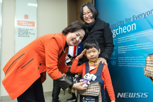 【서울=뉴시스】박대로 기자 =어린이에게 기특한어린이인형을 달아주는 김수영 양천구청장. 2018.12.10. (사진=양천구 제공)