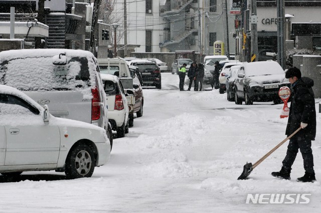 【춘천=뉴시스】박종우 기자 = 11일 오후 대설주의보가 내린 강원 춘천시 효자동 인근 한 도로에서 소복히 쌓인 눈을 한 시민이 치우고 있다. 2018.12.11.jongwoo425@newsis.com