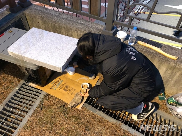 【서울=뉴시스】서울 성북구 삼선동 일대에서 활동하는 동물구조119 활동가 황경옥씨가 지난 10일 오후 고양이 겨울집의 빈 사료 그릇을 채우고 있다. 2018.12.12