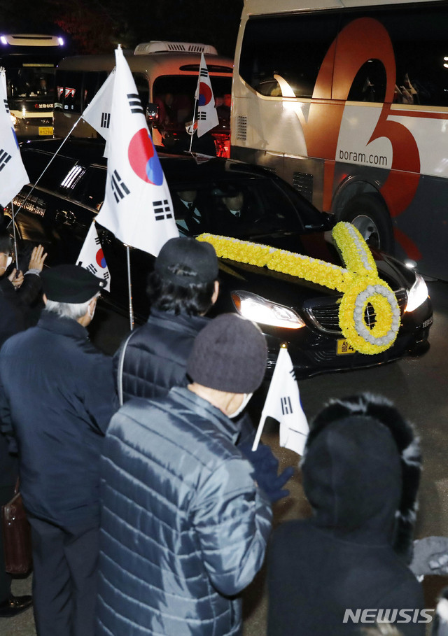 【서울=뉴시스】최동준 기자 = 11일 오전 서울 강남구 삼성서울병원 장례식장에서 고 이재수 전 기무사령관의 발인식이 엄수되고 있다. 보수단체 회원들이 이 전 사령관 운구차 이동 길목에서 태극기를 들고 서 있다. 2018.12.11. photocdj@newsis.com