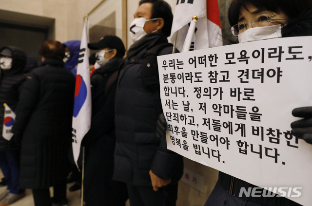 【서울=뉴시스】최동준 기자 = 고 이재수 전 기무사령관의 발인식이 엄수된 11일 오전 서울 강남구 삼성서울병원 장례식장에서 보수단체 회원들이 태극기와 피켓을 들고 서 있다. 2018.12.11. photocdj@newsis.com