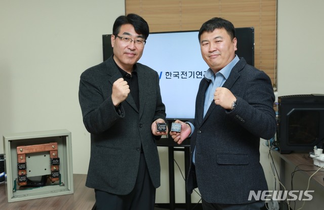 【창원=뉴시스】 홍정명 기자 = 한국전기연구원 배준한(왼쪽) 책임연구원이 기술이전 대상 업체인 엘시그니처 조쌍규 대표이사와 '전기과열 방지 무전원 무선온도진단 기기'를 들고 기념촬영을 하고 있다.2018.12.12.(사진=한국전기연구원 제공) photo@newsis.com