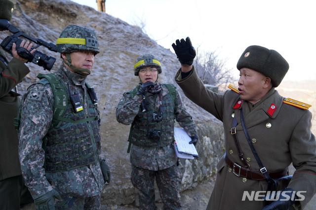 【서울=뉴시스】12일 비무장지대(DMZ)내 감시초소(GP) 시범철수 현장검증이 마무리됐다. 사진은 북측 안내요원이 우리측 검증반에게 북측 GP와 지형 등에 대해 설명하는 모습. 2018.12.12. (사진=국방부 제공) photo@newsis.com 
