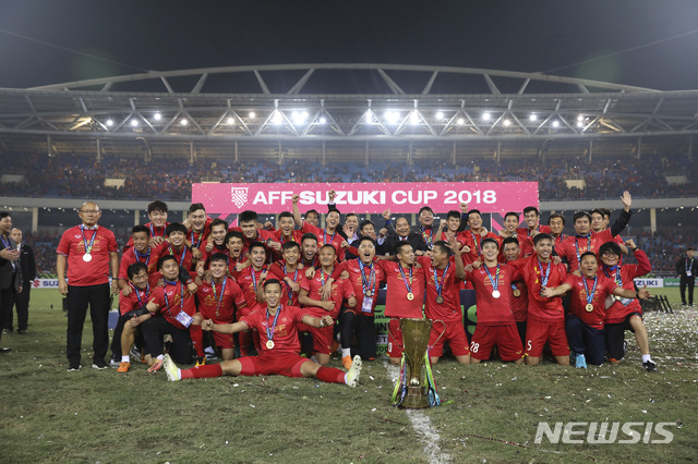 【하노이(베트남)=AP/뉴시스】'쌀딩크' 박항서(59) 감독이 이끄는 베트남 축구가 15일(한국시간) 베트남 하노이의 마이딘 스타디움에서 열린 말레이시아와의 2018 아세안축구연맹(AFF) 스즈키컵 결승 2차전에서 1-0으로 승리했다. 1·2차전 합계 3-2로 앞선 베트남은 2008년 이후 10년 만에 정상을 탈환했다. 베트남 선수단이 우승컵을 앞에 두고 단체사진을 찍고 있다. 가장 왼쪽이 박 감독이다. 2018.12.15.