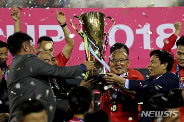 【하노이=AP/뉴시스】15일(현지시간) 베트남 하노이 마이딘 스타디움에서 열린 2018 아세안축구연맹(AFF) 스즈키컵 결승전 최종 2차전에서 베트남을 우승으로 이끈 박항서 감독이 우승컵을 들고 기뻐하고 있다. 베트남은 이 경기에서 전반 6분 안둑의 결승 골로 1-0으로 말레이시아를 누르고 승리하며 10년 만에 이 대회 우승을 차지했다. 2018.12.16.