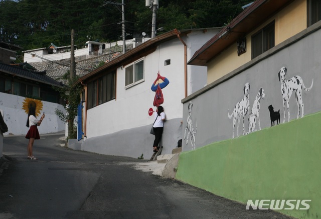 【안동=뉴시스】김진호 기자 = 안동시 신세동 벽화마을을 찾은 방문객이 사진을 찍고 있다. 2018.12.17 (사진=안동시 제공) photo@newsis.com