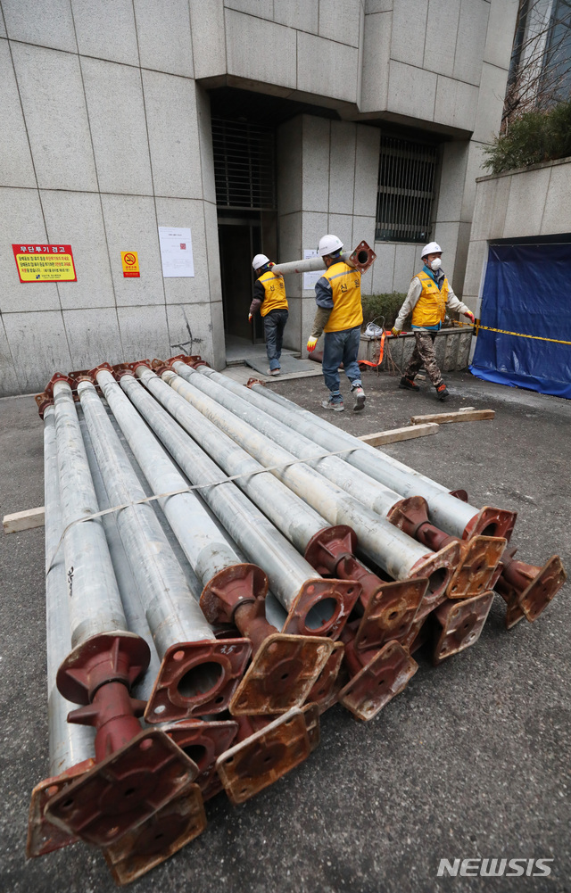 【서울=뉴시스】김진아 기자 = 19일 붕괴 위험에 처한 서울 강남구 삼성동 대종빌딩에서 관계자들이 응급 보강공사 작업을 위해 지지대를 옮기고 있다.&nbsp; 강남구는 이날부터 약 한 달에 걸쳐 지하 1층, 지상 5층 등 총 6개 층에 지지대를 설치하고, 2층 주 기둥 2개의 단면적을 확대하는 방식으로 보강공사를 진행한다고 밝혔다. 2018.12.19.&nbsp; bluesoda@newsis.com