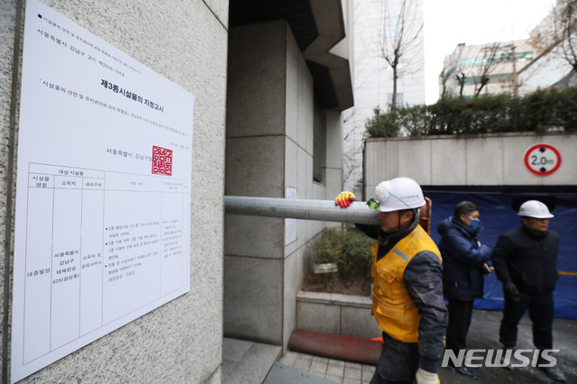 【서울=뉴시스】김진아 기자 = 19일 붕괴 위험에 처한 서울 강남구 삼성동 대종빌딩에서 관계자들이 응급 보강공사 작업을 위해 지지대를 옮기고 있다.&nbsp; 강남구는 이날부터 약 한 달에 걸쳐 지하 1층, 지상 5층 등 총 6개 층에 지지대를 설치하고, 2층 주 기둥 2개의 단면적을 확대하는 방식으로 보강공사를 진행한다고 밝혔다. 2018.12.19.&nbsp; bluesoda@newsis.com