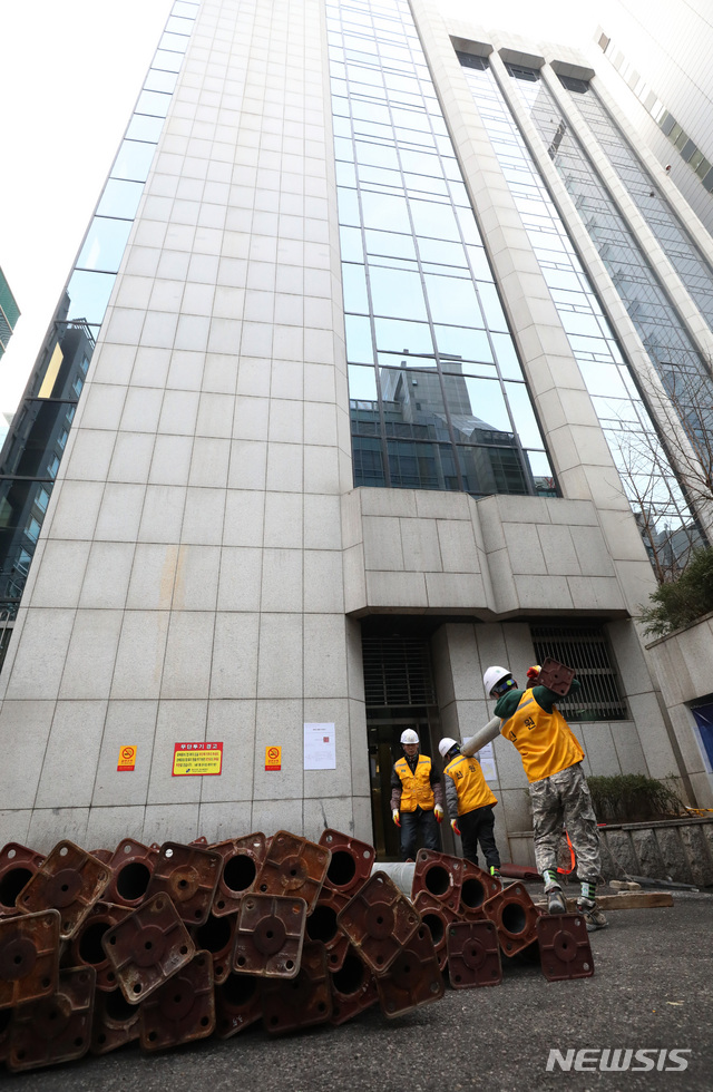 【서울=뉴시스】김진아 기자 = 19일 붕괴 위험에 처한 서울 강남구 삼성동 대종빌딩에서 관계자들이 응급 보강공사 작업을 위해 지지대를 옮기고 있다. 강남구는 이날부터 약 한 달에 걸쳐 지하 1층, 지상 5층 등 총 6개 층에 지지대를 설치하고, 2층 주 기둥 2개의 단면적을 확대하는 방식으로 보강공사를 진행한다고 밝혔다. 2018.12.19. bluesoda@newsis.com