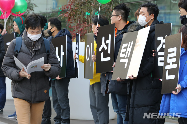 【성남=뉴시스】박미소 수습기자 = 19일 오전 경기도 성남시 네이버 본사 앞에서 민주노총 화섬식품노조 네이버지회 ‘공동성명’ 주최로 열린 공동행동에 참여한 노조원들 앞을 한 시민이 지나고 있다. 2018.12.19. misocamera@newsis.com