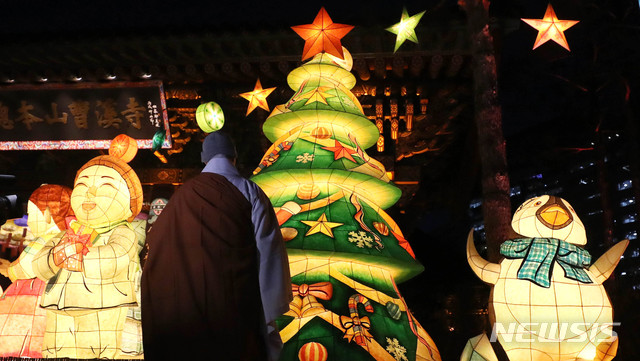 【서울=뉴시스】추상철 기자 = 조계사 '성탄 크리스마스 트리' 점등식이 열린 19일 오후 서울 종로구 조계사 일주문 앞에서 스님이 점등된 트리를 살펴보고 있다. 2018.12.19. scchoo@newsis.com