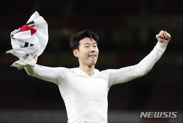 Tottenham's Son Heung-min celebrates holding South Korea's flag after the English League Cup quarter final soccer match between Arsenal and Tottenham Hotspur at the Emirates stadium in London, Wednesday, Dec. 19, 2018. (AP Photo/Frank Augstein)